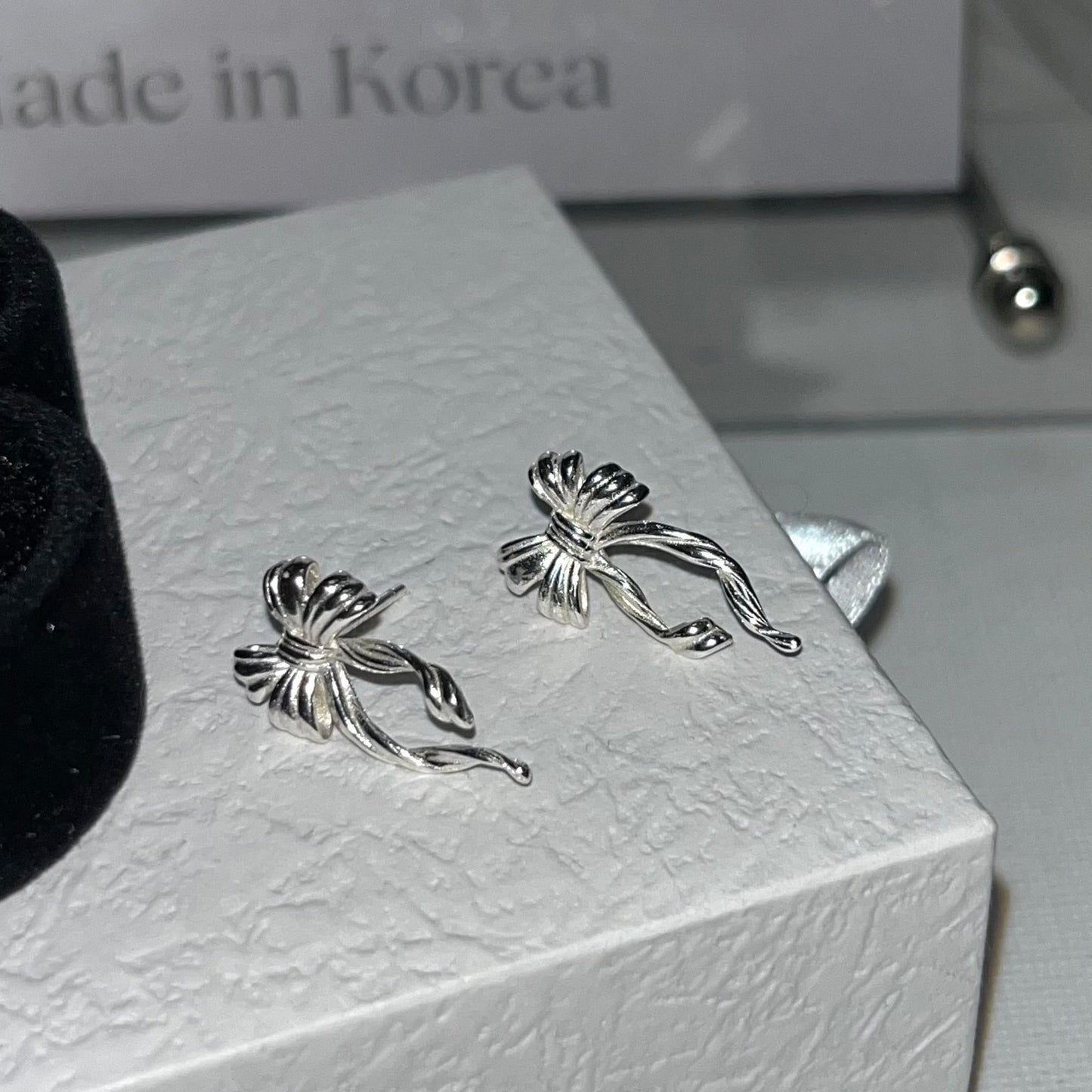 Discover the elegant E42 The Bow Earrings, crafted from premium 925 silver for a timeless shine. This Korea-inspired accessory features delicate bow motifs, perfect for everyday glamour or special occasions. Hypoallergenic, lightweight, and versatile—elevate your style with subtle sophistication. Ideal for fashion enthusiasts seeking affordable luxury.

#SilverEarrings, #925SterlingSilver, #SterlingSilverEarrings, #SilverJewelry, #HandmadeEarrings, #StatementEarrings, #EarringStyle, #MinimalistEarrings, #Fa