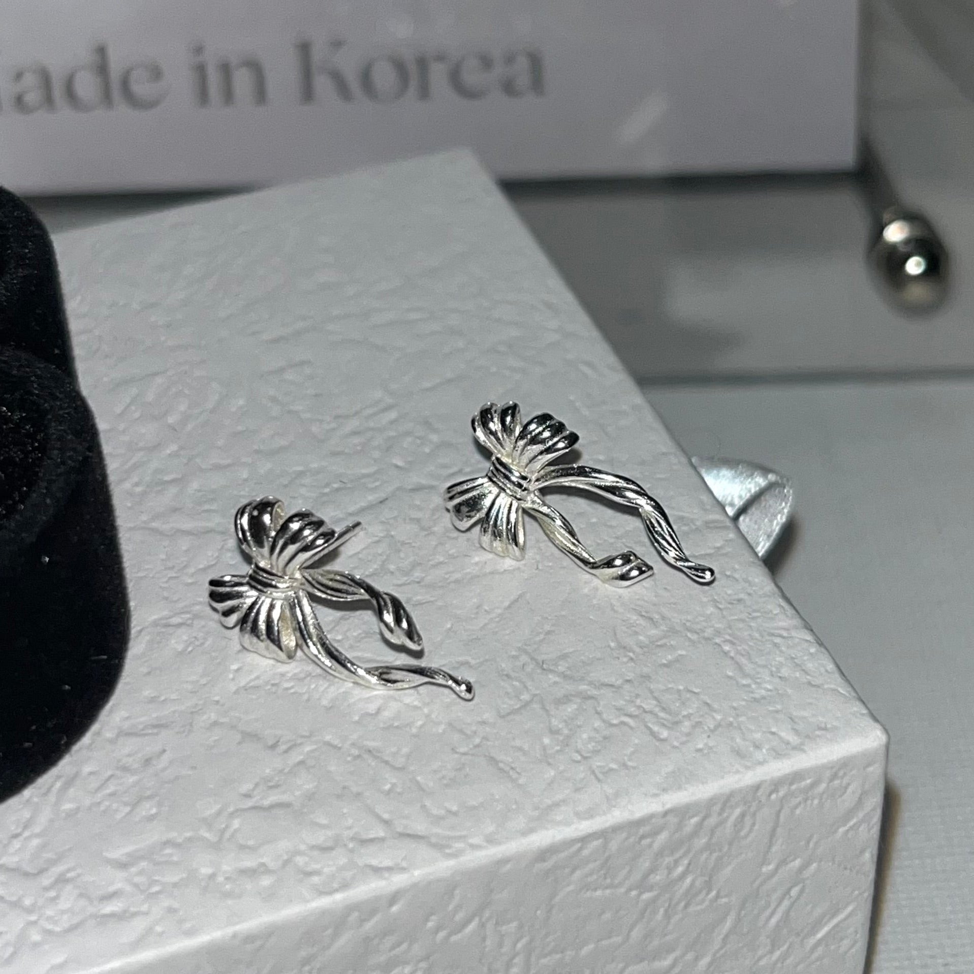 Discover the elegant E42 The Bow Earrings, crafted from premium 925 silver for a timeless shine. This Korea-inspired accessory features delicate bow motifs, perfect for everyday glamour or special occasions. Hypoallergenic, lightweight, and versatile—elevate your style with subtle sophistication. Ideal for fashion enthusiasts seeking affordable luxury.

#SilverEarrings, #925SterlingSilver, #SterlingSilverEarrings, #SilverJewelry, #HandmadeEarrings, #StatementEarrings, #EarringStyle, #MinimalistEarrings, #Fa
