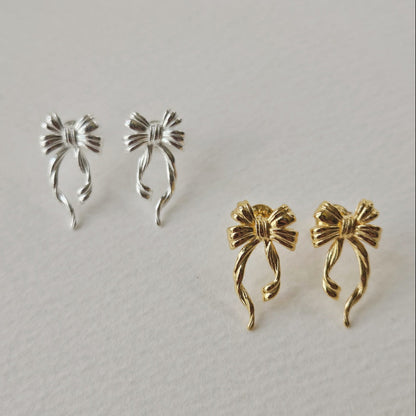 Discover the elegant E42 The Bow Earrings, crafted from premium 925 silver for a timeless shine. This Korea-inspired accessory features delicate bow motifs, perfect for everyday glamour or special occasions. Hypoallergenic, lightweight, and versatile—elevate your style with subtle sophistication. Ideal for fashion enthusiasts seeking affordable luxury.

#SilverEarrings, #925SterlingSilver, #SterlingSilverEarrings, #SilverJewelry, #HandmadeEarrings, #StatementEarrings, #EarringStyle, #MinimalistEarrings, #Fa